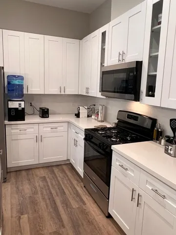 a kitchen with a sink stove and white cabinets