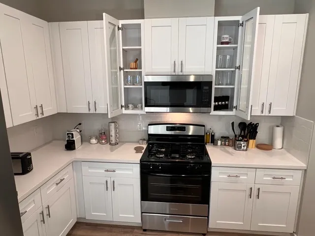 a kitchen with cabinets stainless steel appliances and wooden floor