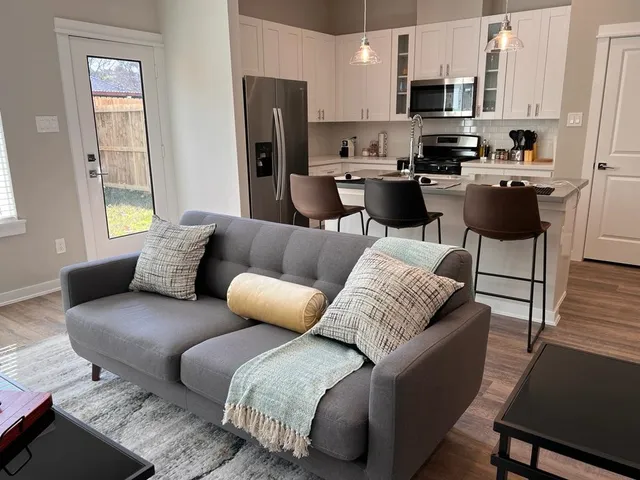 a living room with stainless steel appliances furniture and a window