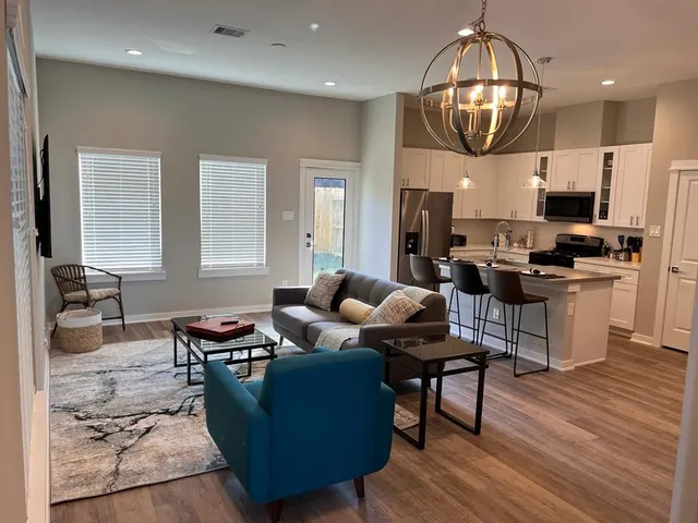 a living room with furniture kitchen and a chandelier