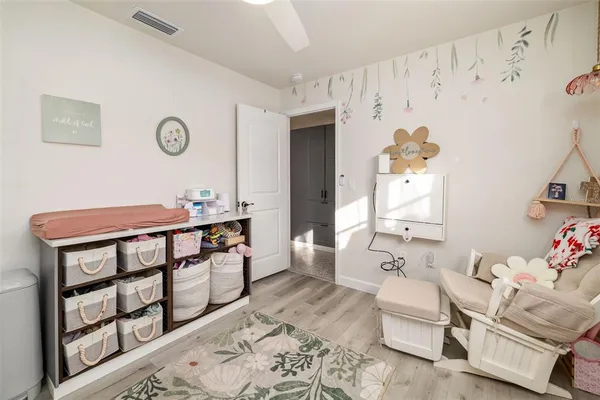 a kitchen with stainless steel appliances a refrigerator a stove a dining table and chairs with wooden floor