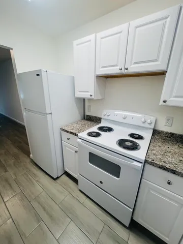a kitchen with white cabinets and white appliances