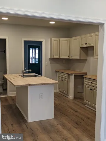 a kitchen with kitchen island a sink dishwasher stove and oven with wooden floor