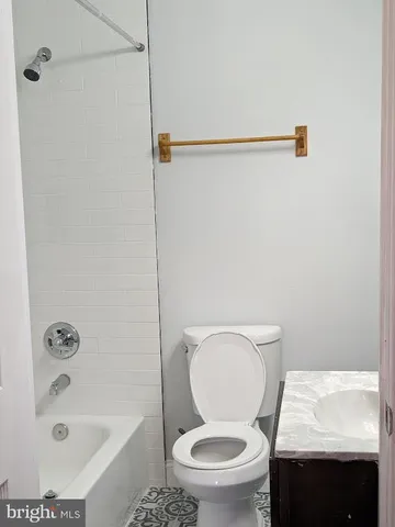 a white toilet sitting next to a bath tub