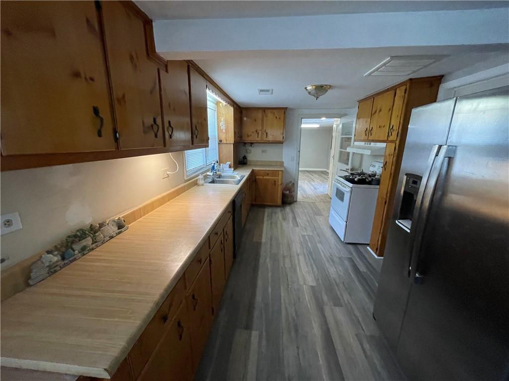 71 McGuire Road Dallas, GA 30157 - Photo 7 of 26 a kitchen with stainless steel appliances cabinets a sink and a wooden floor