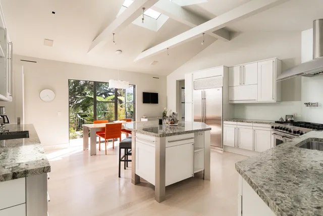 a bathroom with a granite countertop sink and a large mirror