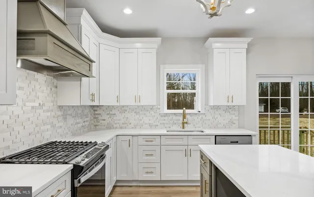 a kitchen with granite countertop a sink stove and cabinets