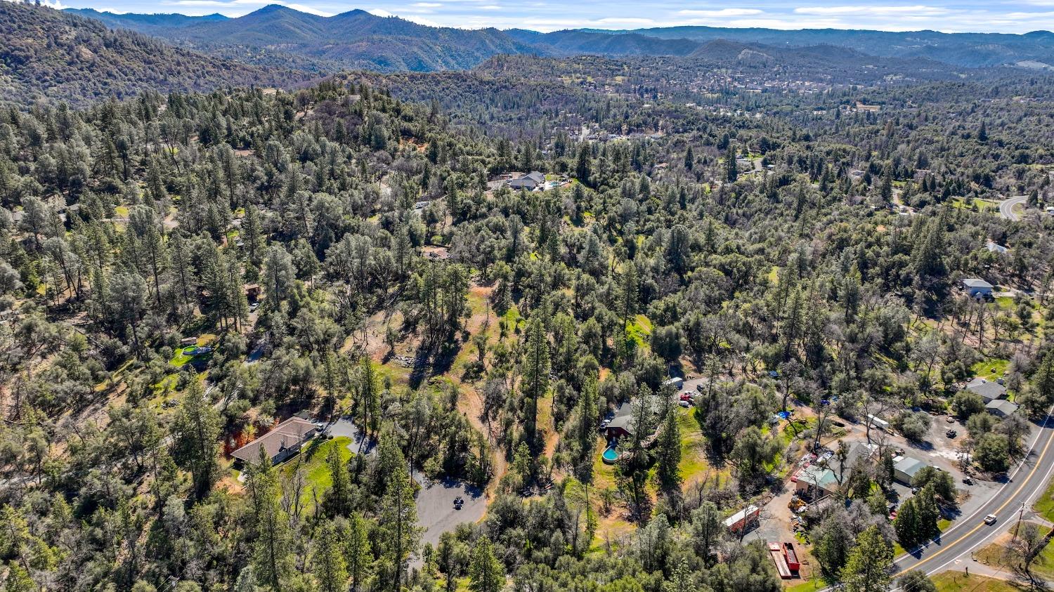 20275 Tuolumne Road North Tuolumne, CA 95379 - Photo 32 of 58 a view of a lush green field with mountains in the background