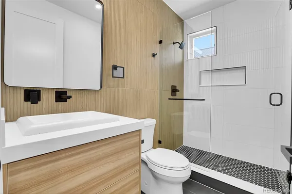 a bathroom with a sink a toilet and shower