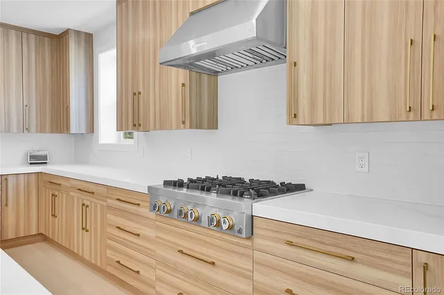 a kitchen with white cabinets and a stove top oven