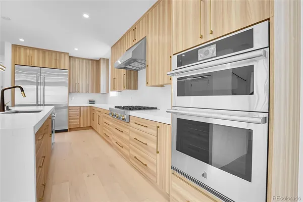 a kitchen with stainless steel appliances granite countertop a stove microwave and cabinets