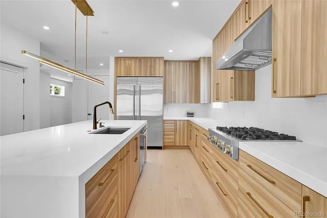 a kitchen with stainless steel appliances granite countertop a sink a stove and a refrigerator