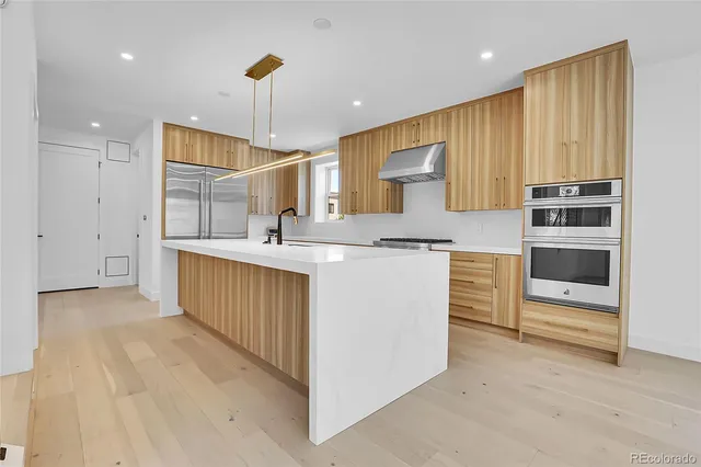a kitchen with kitchen island a sink stainless steel appliances and cabinets