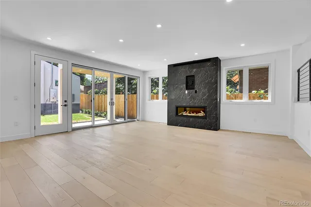 a view of an empty room with a fireplace and a window