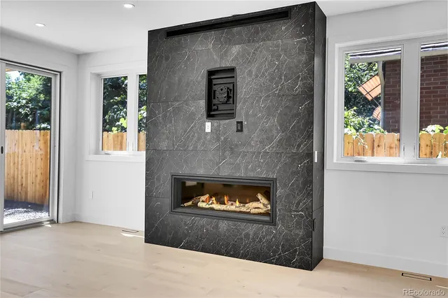 an empty room with windows and fireplace