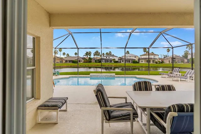 a view of a swimming pool and a dinning table and chairs in patio