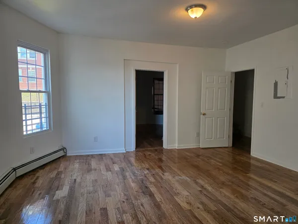 an empty room with wooden floor and windows