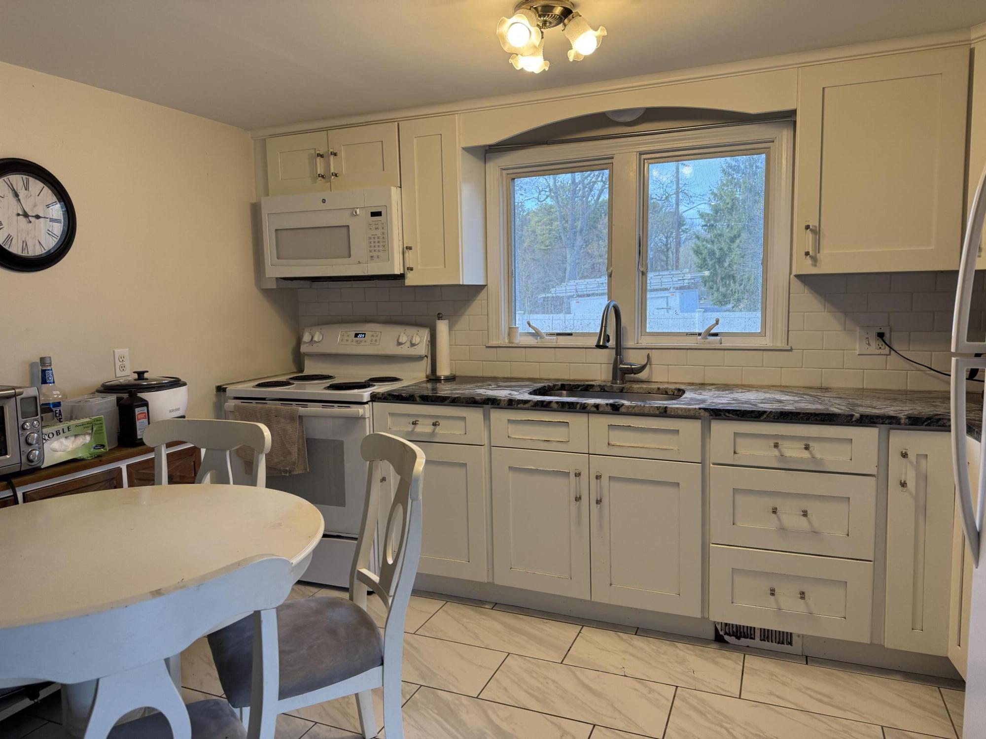 299 Winslow Gray Road West Yarmouth, MA 02673 - Photo 12 of 19 a kitchen with white cabinets and sink