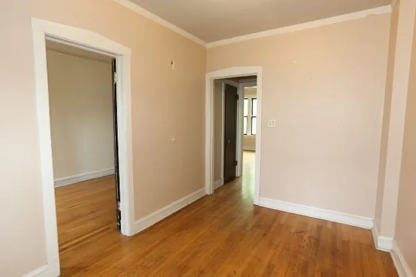 an empty room with wooden floor and closet