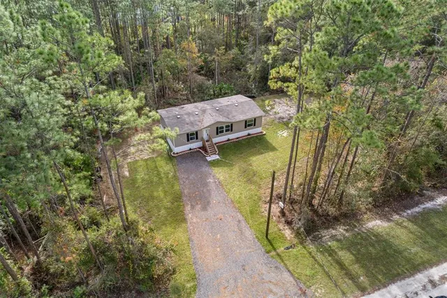 a aerial view of a house with swimming pool and large trees