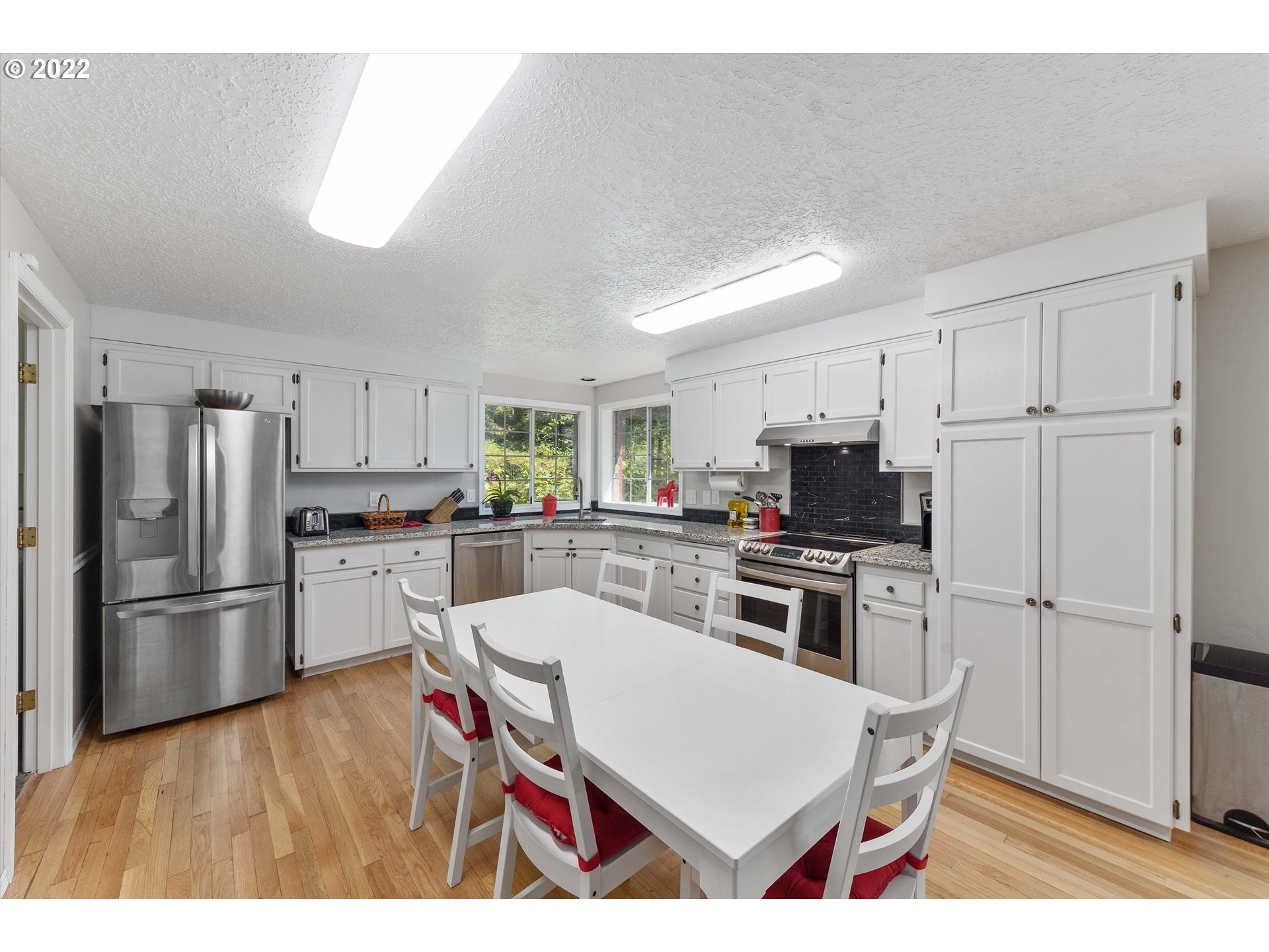 17212 Southeast Royer Road Damascus, OR 97089 - Photo 6 of 32 a kitchen with white cabinets and stainless steel appliances