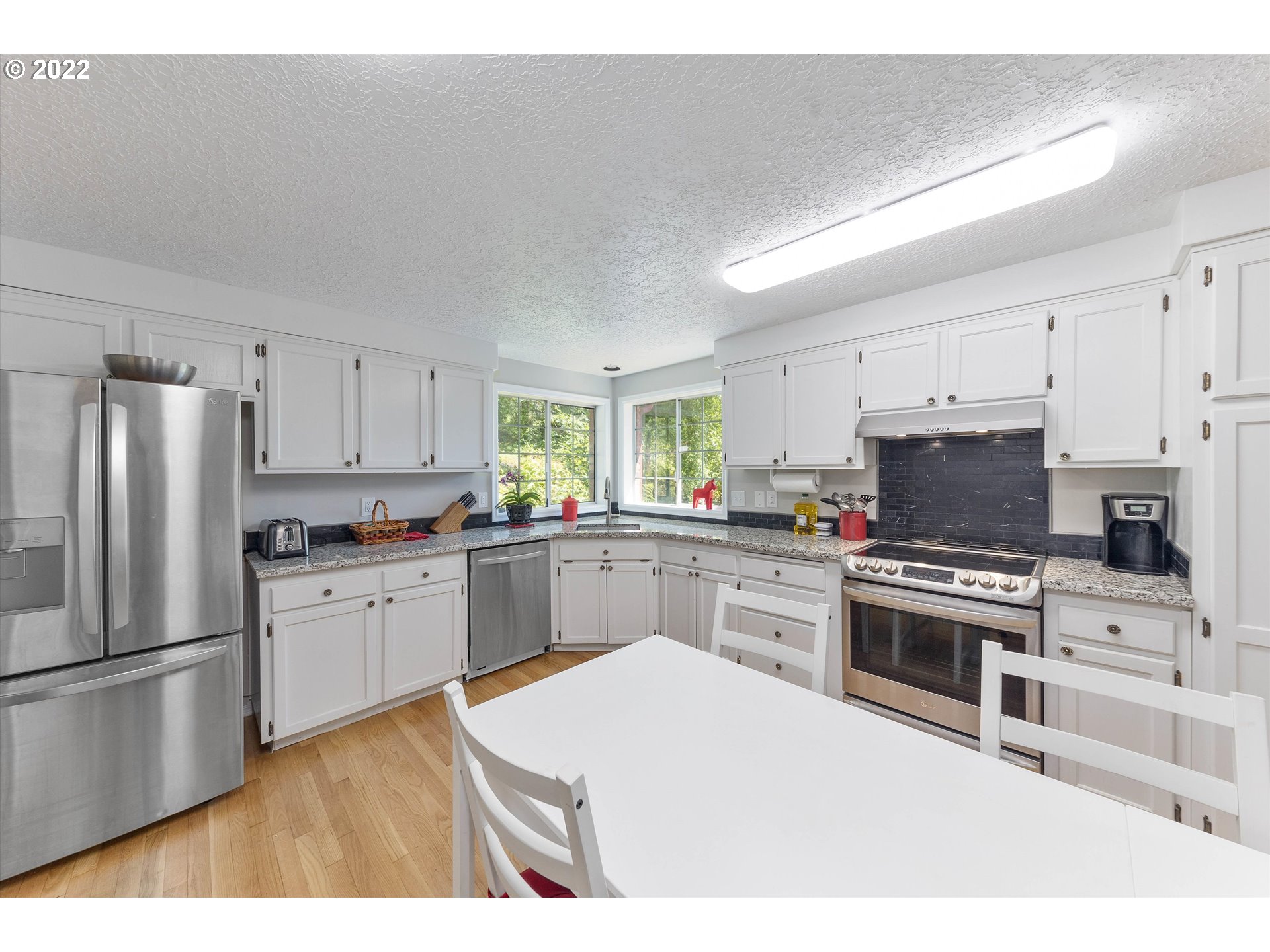 17212 Southeast Royer Road Damascus, OR 97089 - Photo 7 of 32 a kitchen with a refrigerator stove top oven and sink