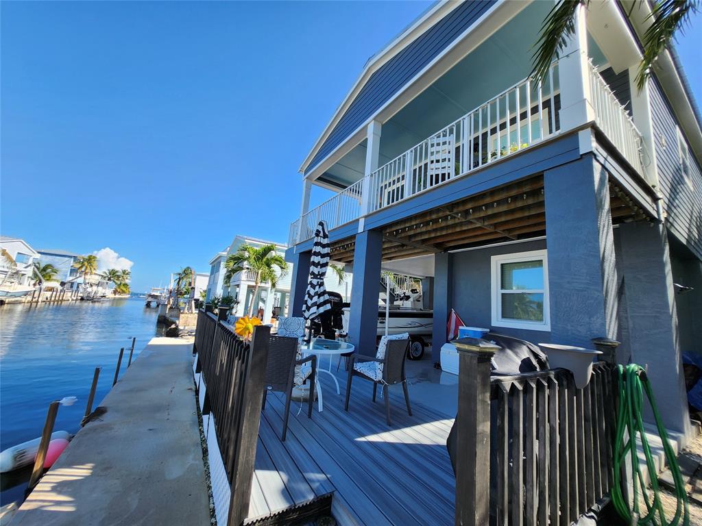 31547 Ave D Big Pine Key, FL 33043 - Photo 15 of 42 a view of a house with patio outdoor dining space and furniture