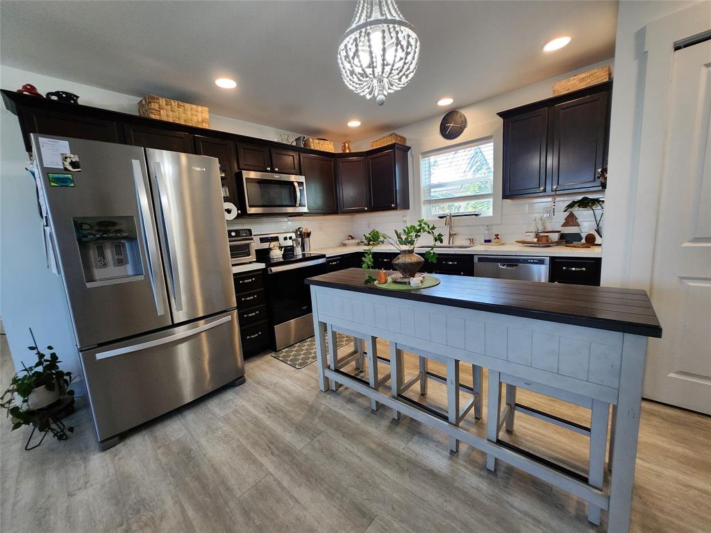 31547 Ave D Big Pine Key, FL 33043 - Photo 7 of 42 a kitchen with stainless steel appliances granite countertop a refrigerator a stove a sink and a microwave