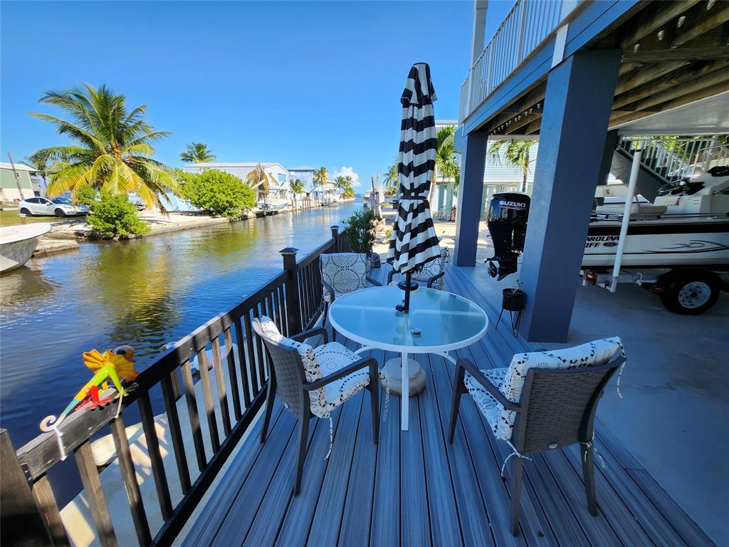 31547 Ave D Big Pine Key, FL 33043 - Photo 9 of 42 a view of a balcony with chairs and wooden floor