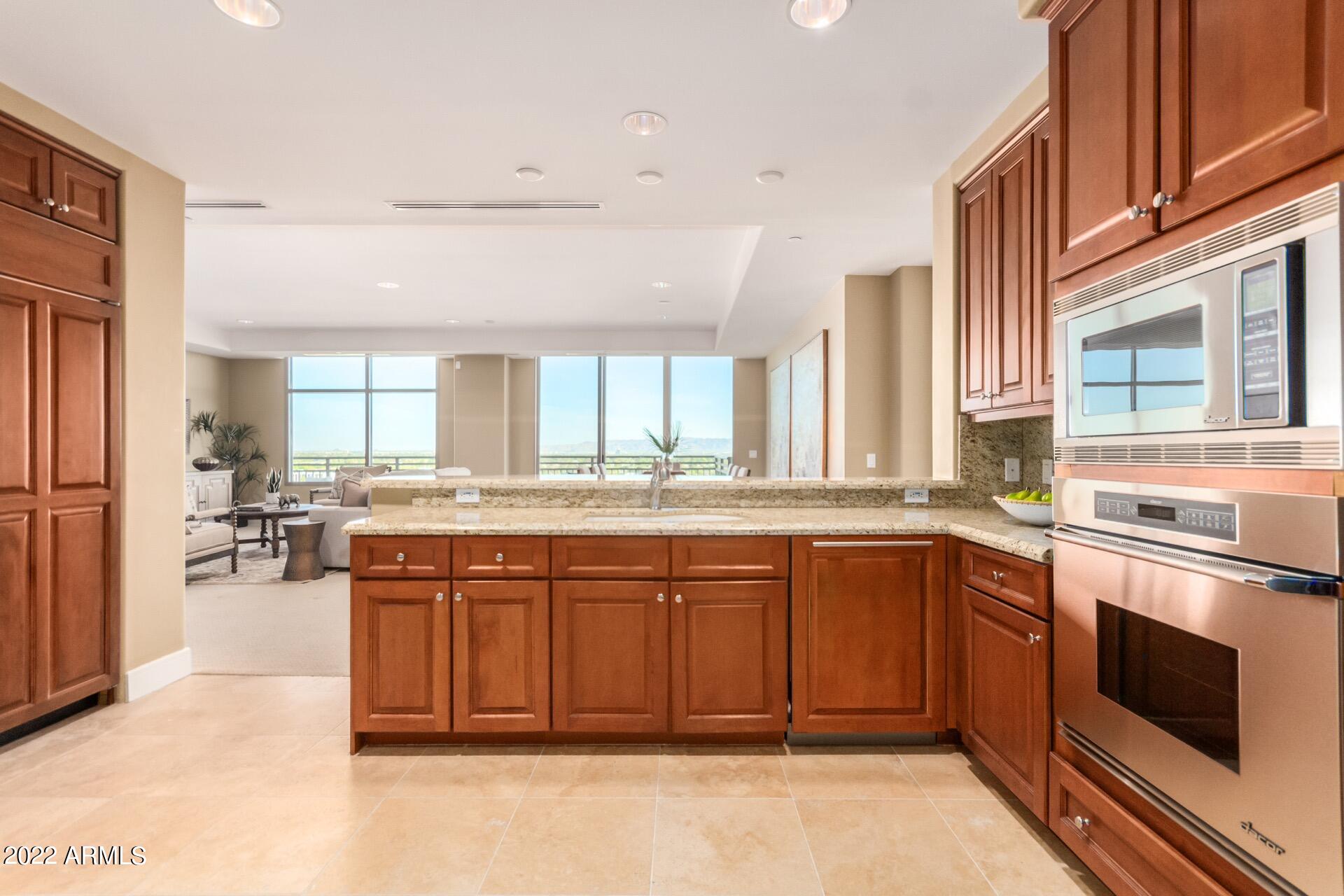 2211 East Camelback Road, Unit 1104 Phoenix, AZ 85016 - Photo 12 of 43 a large kitchen with stainless steel appliances granite countertop a stove and more cabinets