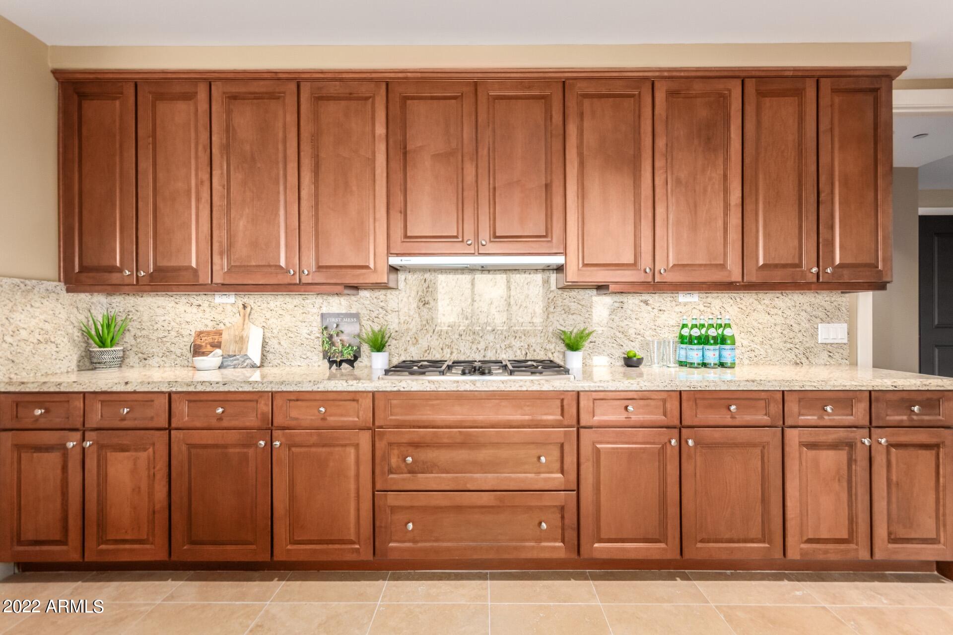 2211 East Camelback Road, Unit 1104 Phoenix, AZ 85016 - Photo 15 of 43 a kitchen with granite countertop wooden cabinets and sink
