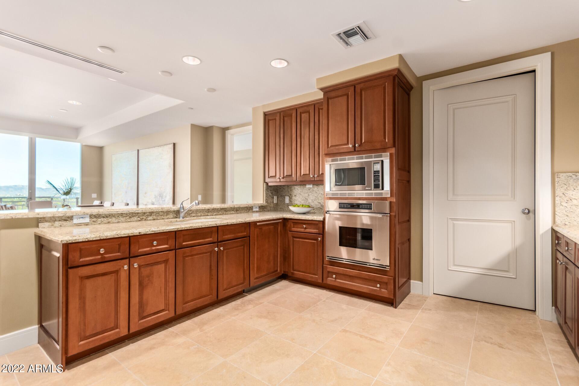2211 East Camelback Road, Unit 1104 Phoenix, AZ 85016 - Photo 16 of 43 a kitchen with stainless steel appliances granite countertop a stove and a refrigerator