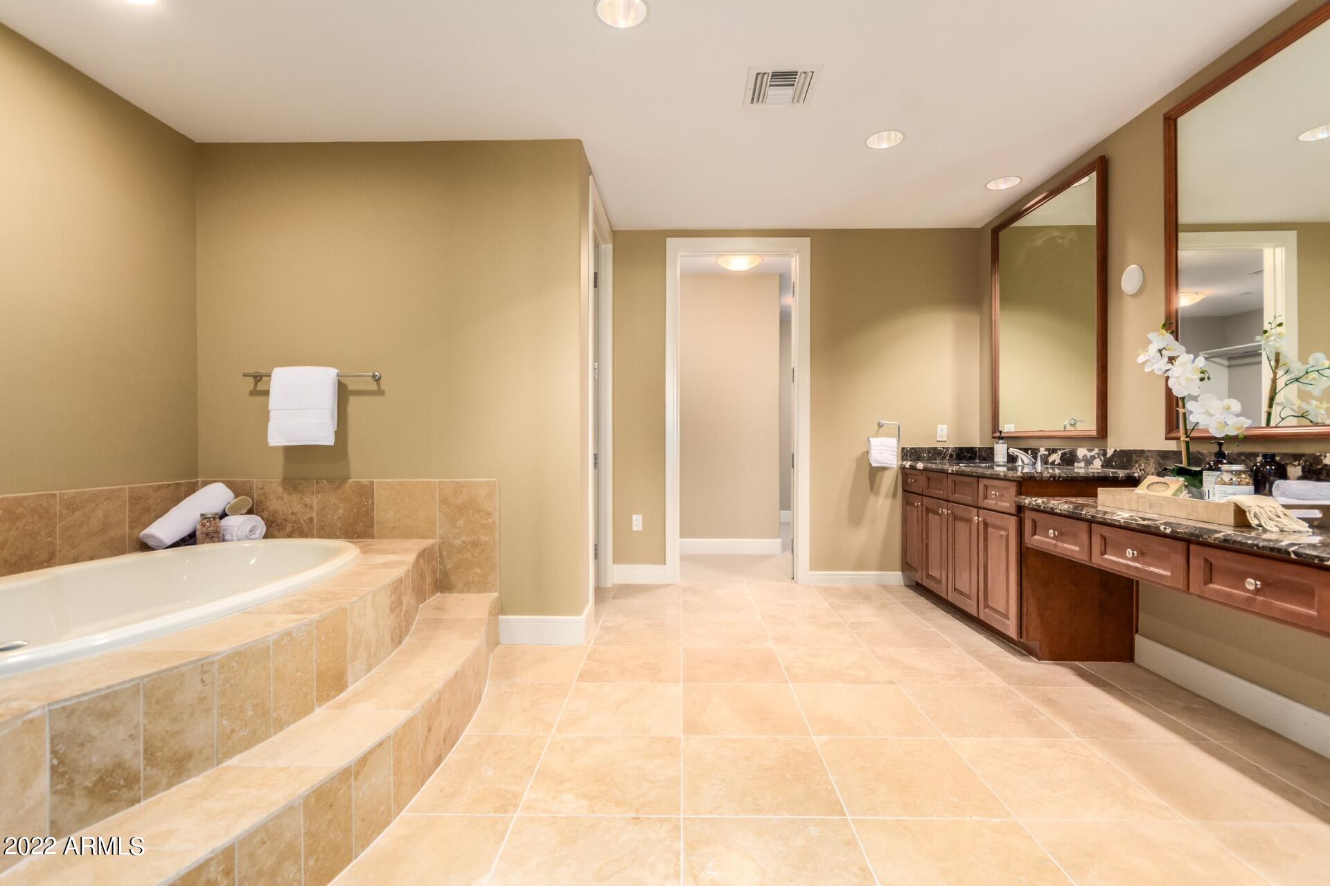 2211 East Camelback Road, Unit 1104 Phoenix, AZ 85016 - Photo 22 of 43 a large bathroom with a tub sink and mirror