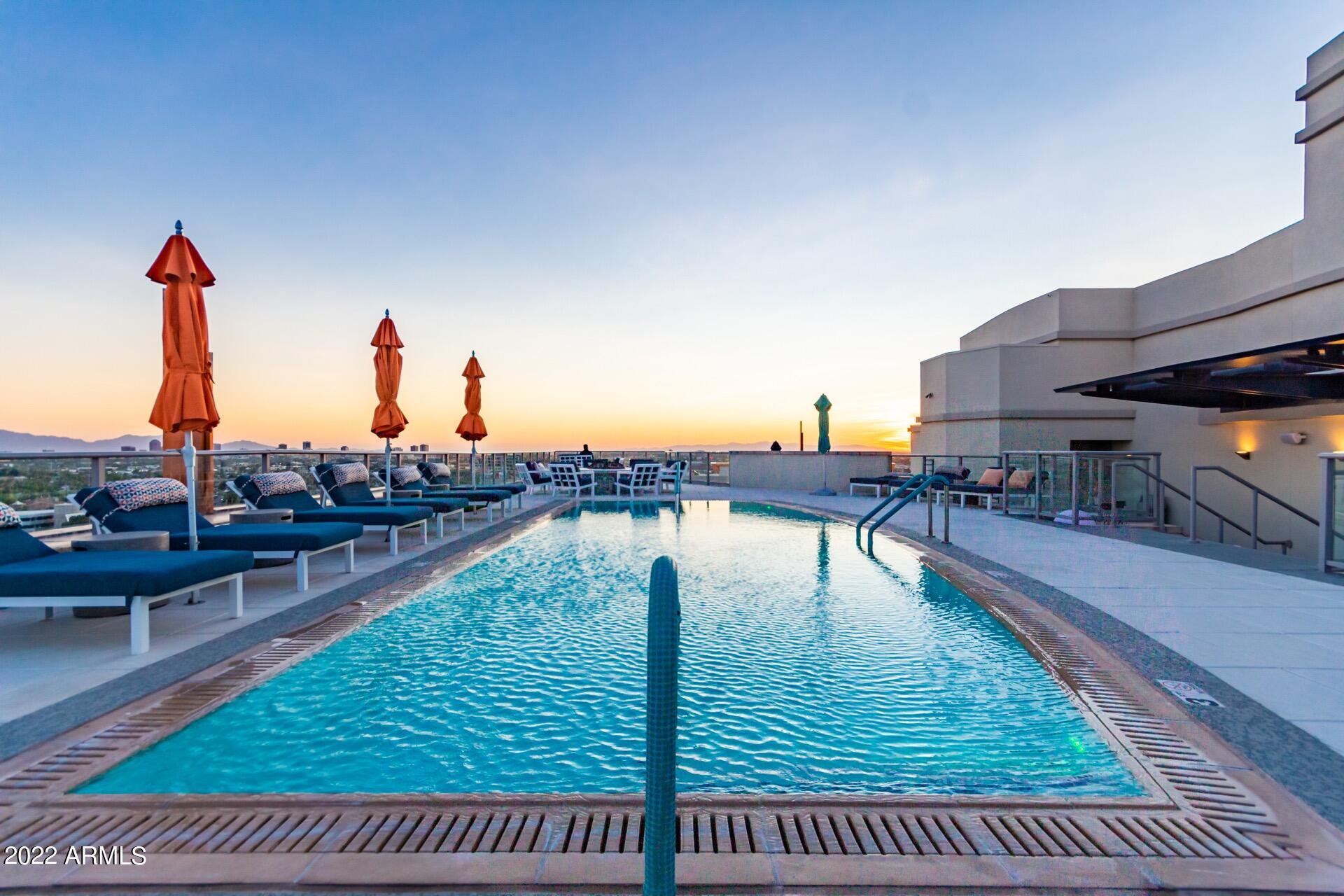 2211 East Camelback Road, Unit 1104 Phoenix, AZ 85016 - Photo 33 of 43 a view of a swimming pool with a deck and living room