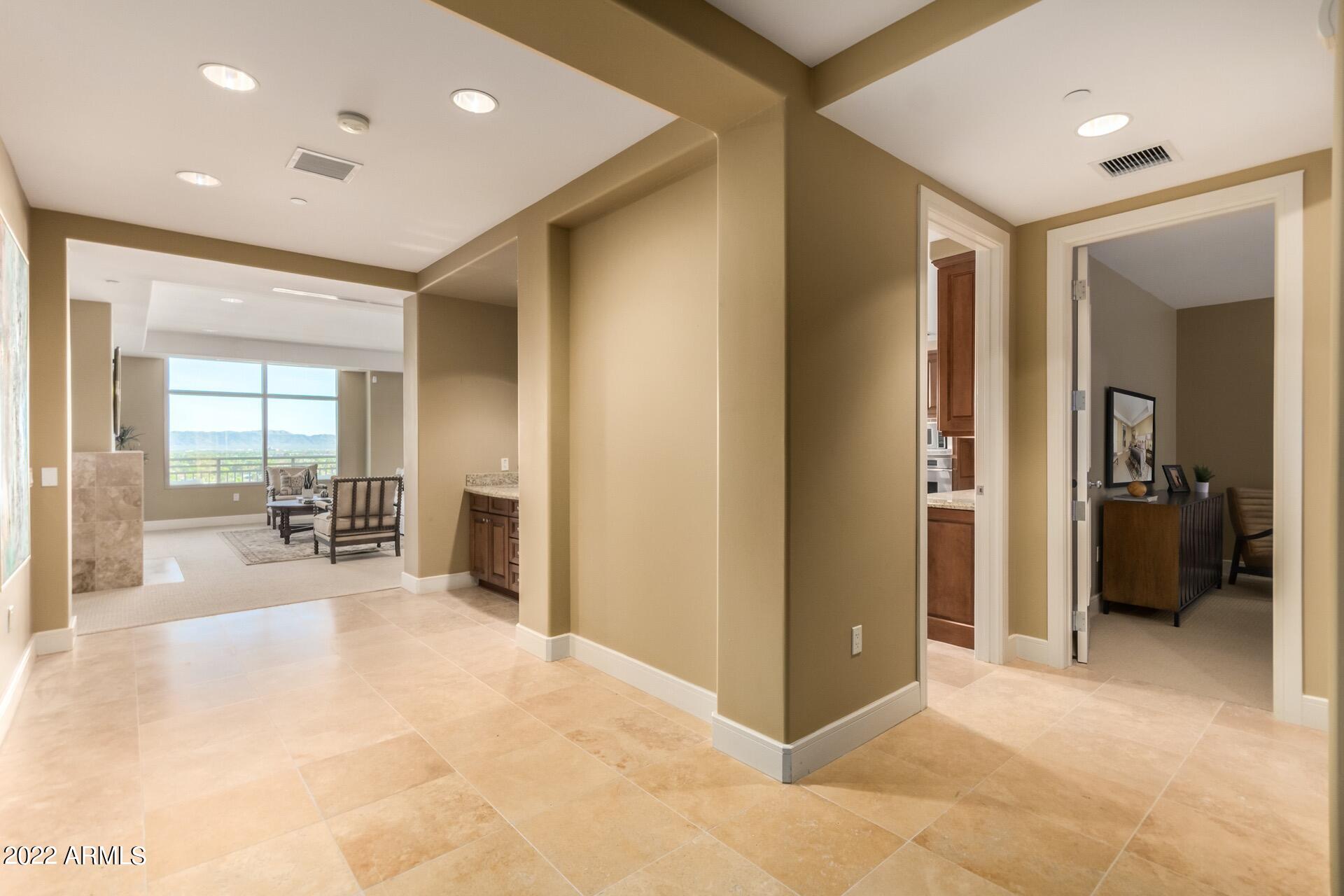 2211 East Camelback Road, Unit 1104 Phoenix, AZ 85016 - Photo 5 of 43 a view of a hallway with wooden floor and a living room