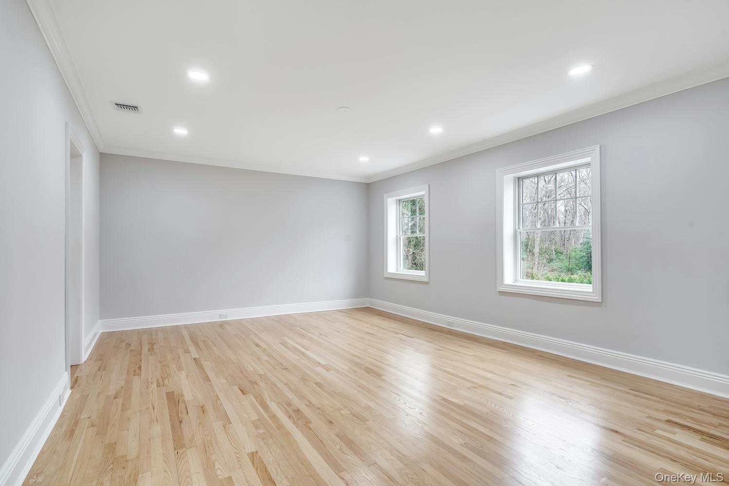 539 Split Rock Road Syosset, NY 11791 - Photo 20 of 40 Empty room featuring baseboards, visible vents, ornamental molding, and light wood-type flooring
