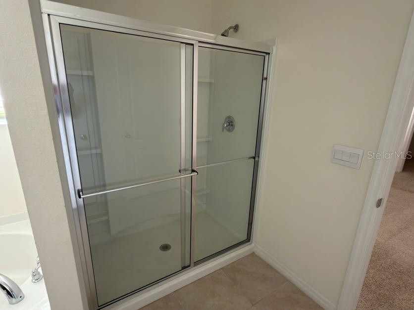 7604 Oakmoss Loop Davenport, FL 33837 - Photo 13 of 16 a bathroom with a glass shower door
