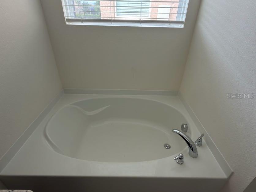 7604 Oakmoss Loop Davenport, FL 33837 - Photo 14 of 16 a close up of a bathtub in a bathroom