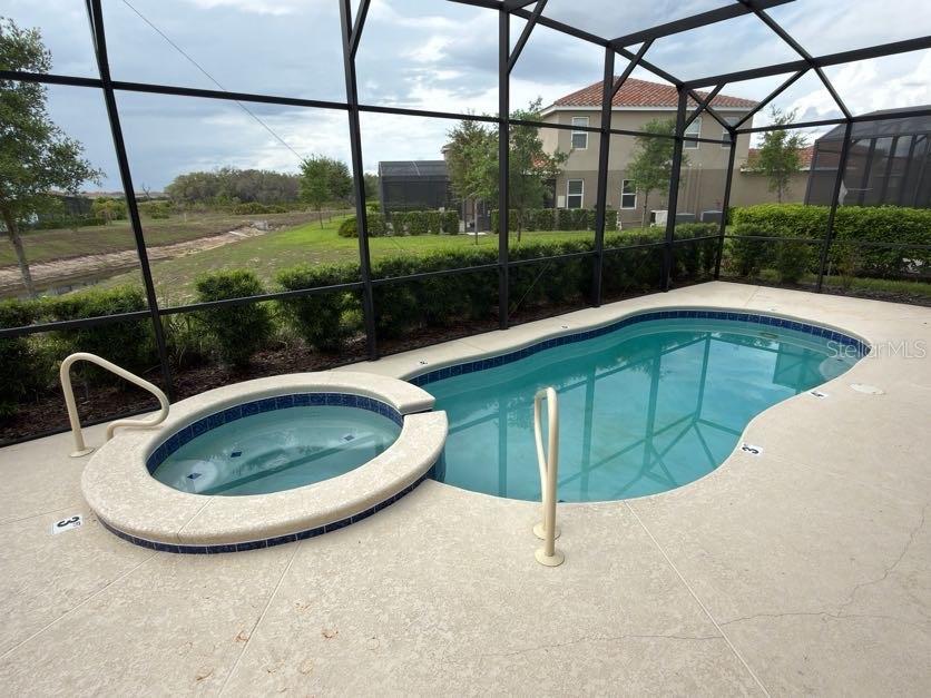 7604 Oakmoss Loop Davenport, FL 33837 - Photo 16 of 16 a view of a swimming pool with a porch next to a yard