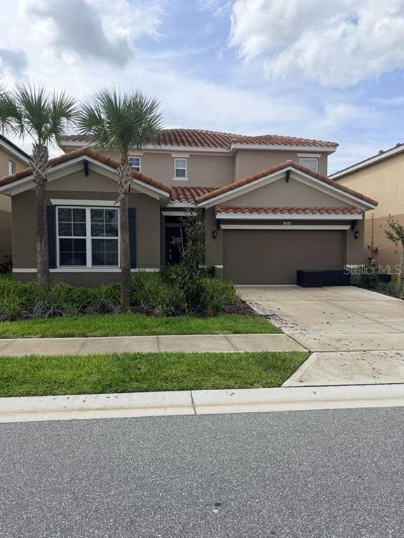 7604 Oakmoss Loop Davenport, FL 33837 - Photo 2 of 16 a front view of house with yard and green space