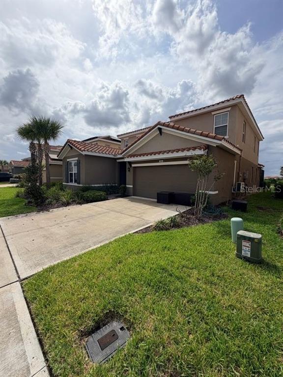 7604 Oakmoss Loop Davenport, FL 33837 - Photo 3 of 16 a front view of a house with a garden