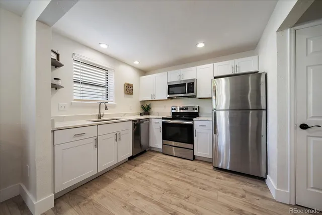 a kitchen with a refrigerator cabinets and wooden floor