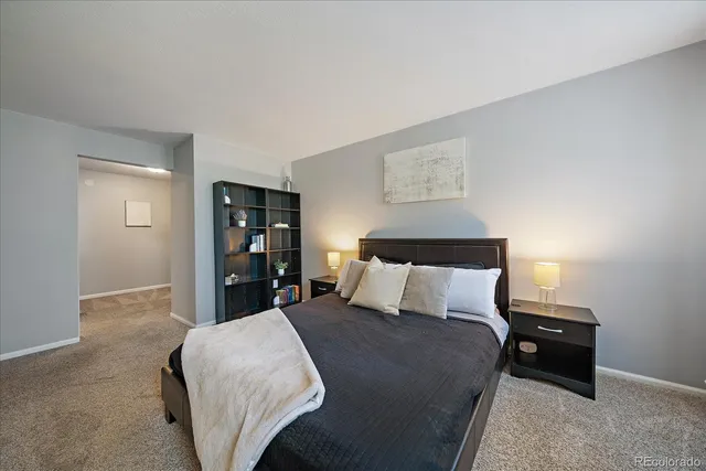 a bed sitting in a bedroom next to a lamp