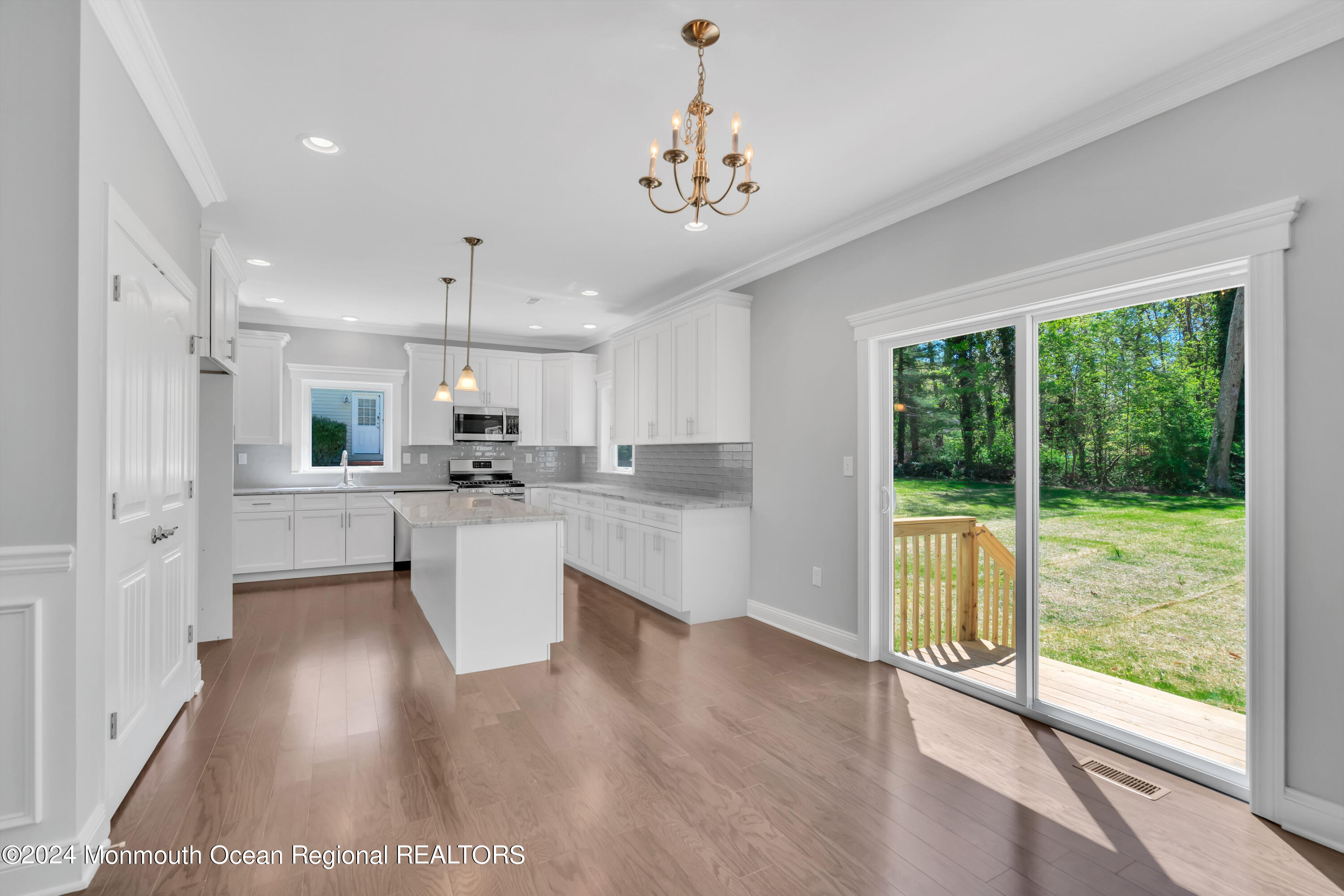 10 Sander Way Bayville, NJ 08721 - Photo 6 of 30 a kitchen with kitchen island wooden floors white cabinets and stainless steel appliances