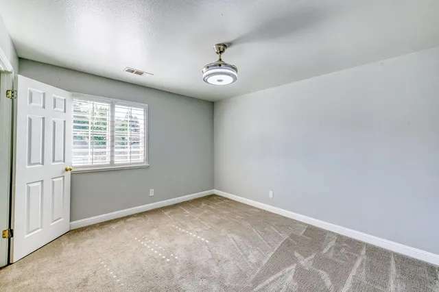 an empty room with fireplace and windows