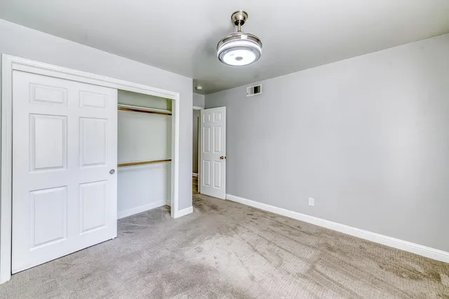 a view of a hallway with wooden floor and a bathroom