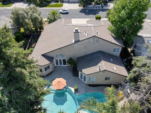 a view of a patio with table and chairs potted plants and a large tree