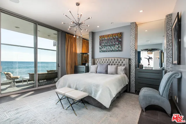 a bedroom with a bed and a chandelier