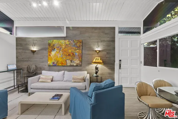 a living room with furniture and a floor to ceiling window
