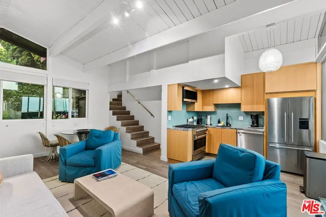 a kitchen with stainless steel appliances a refrigerator a stove a sink a center island and a refrigerator